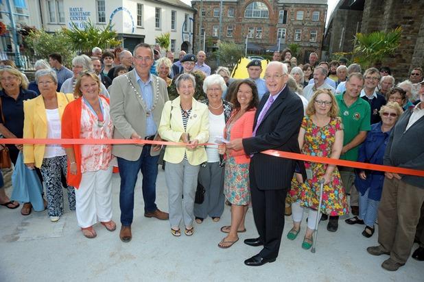 The mayor of Hayle Nick Farrar and president of the Hayle Branch of the RNLI Pauline Marks (centre) watched by members of the community cut the ribbon to officially re-open the Isis gardens in Foundry Square in Hayle